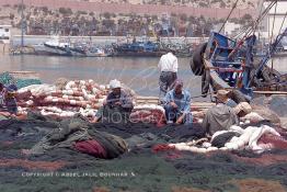 Image du Maroc Professionnelle de  Quelques ouvriers s'activent à réparer les filets de pêche sur un des quais au port d'Agadir, ville située au sud du Maroc, Vendredi 23 Août 2002. (Photo / Abdeljalil Bounhar)

 